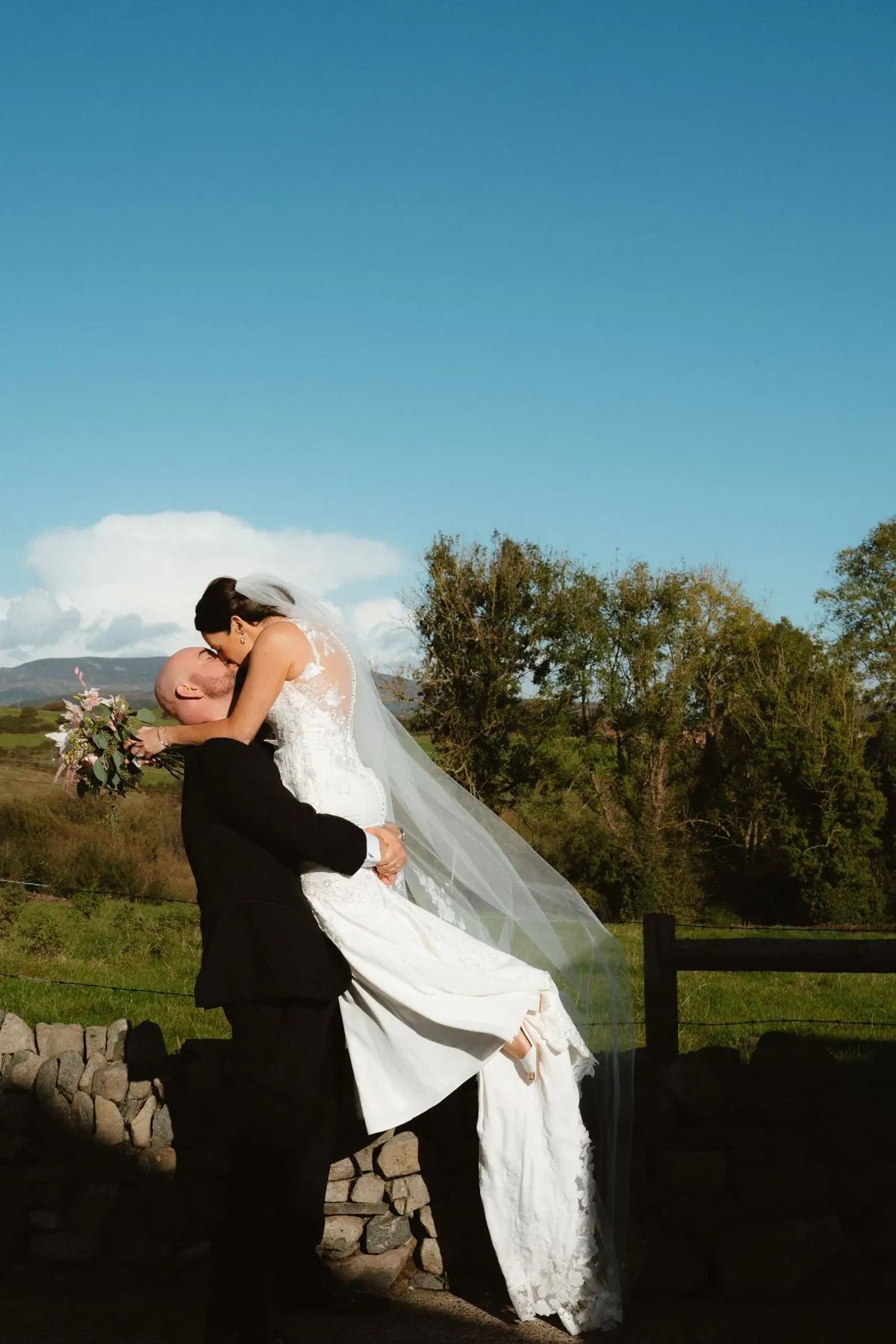 Groom lifts bride at Killeavy Castle during wedding portraits