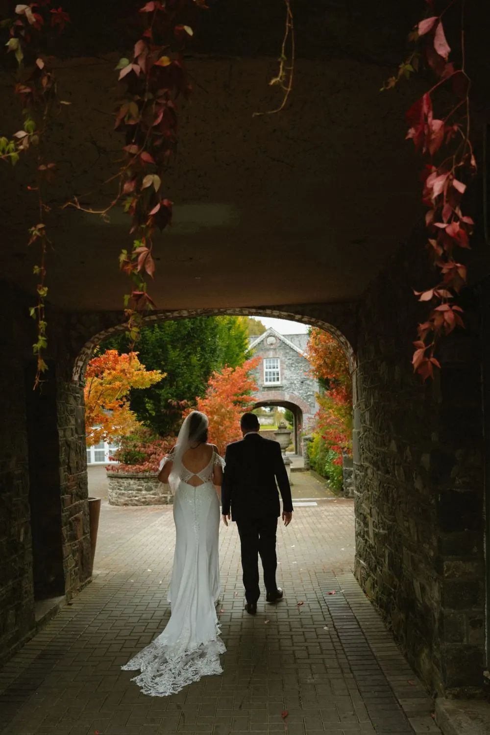 Aine and John together beneath a stone archway at Virginia Park Lodge.