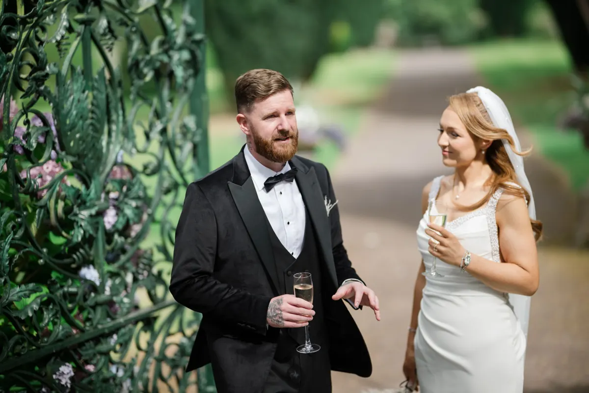 Keara and Craig sharing a drink beside the garden gates at Tankardstown House, County Meath.