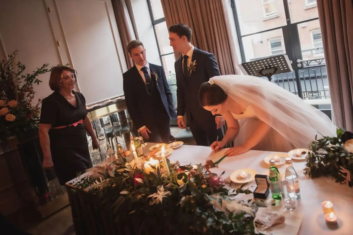 The bride signing at the ceremony table
