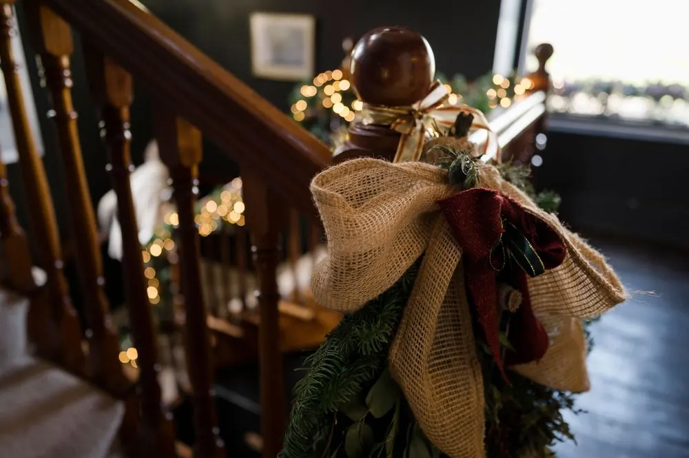 Christmas staircase decorated with garland, burlap bow, and twinkling lights at Boyne Hill House Estate, Co.Meath