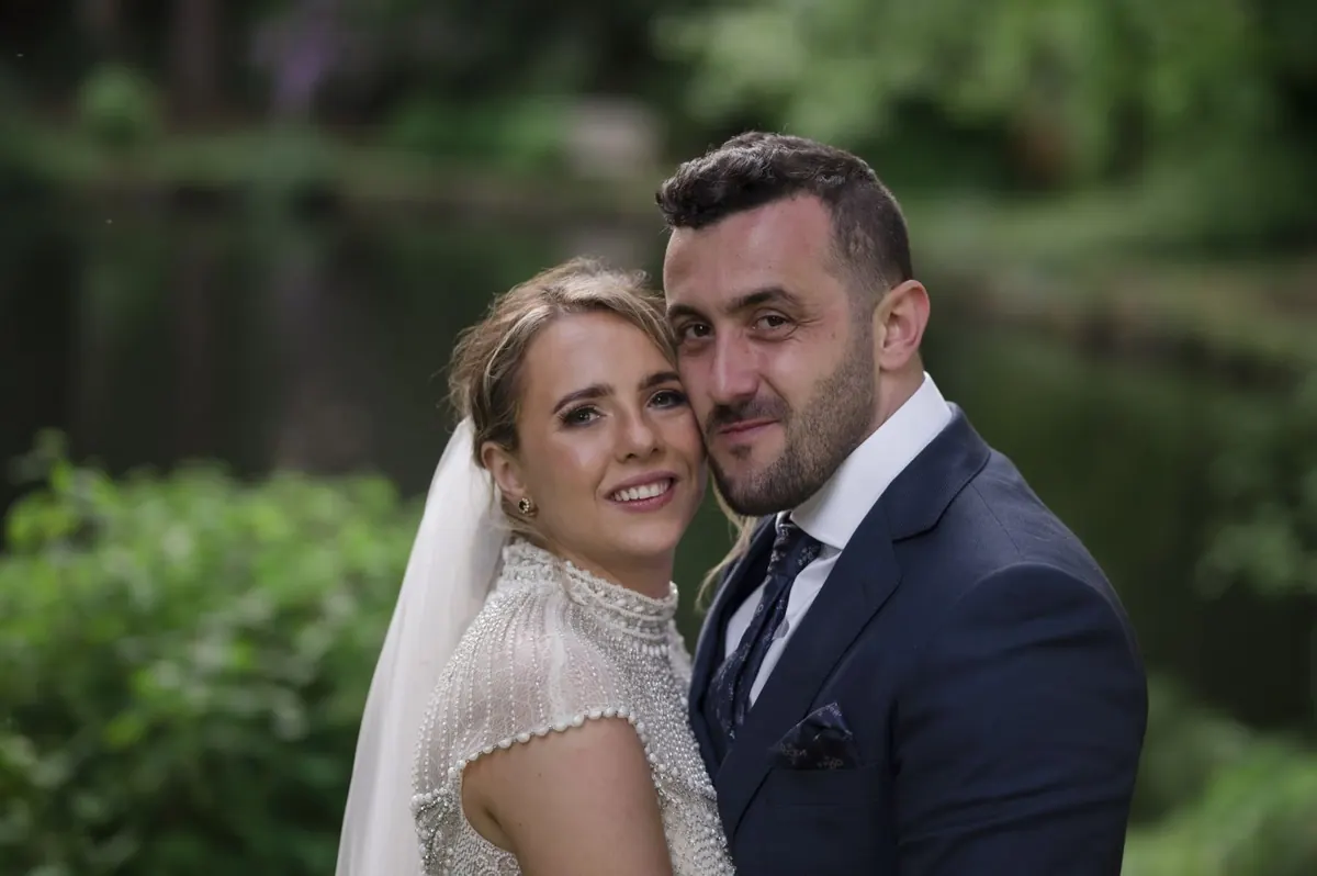 A close portrait of Steph and Ramon against the garden greenery