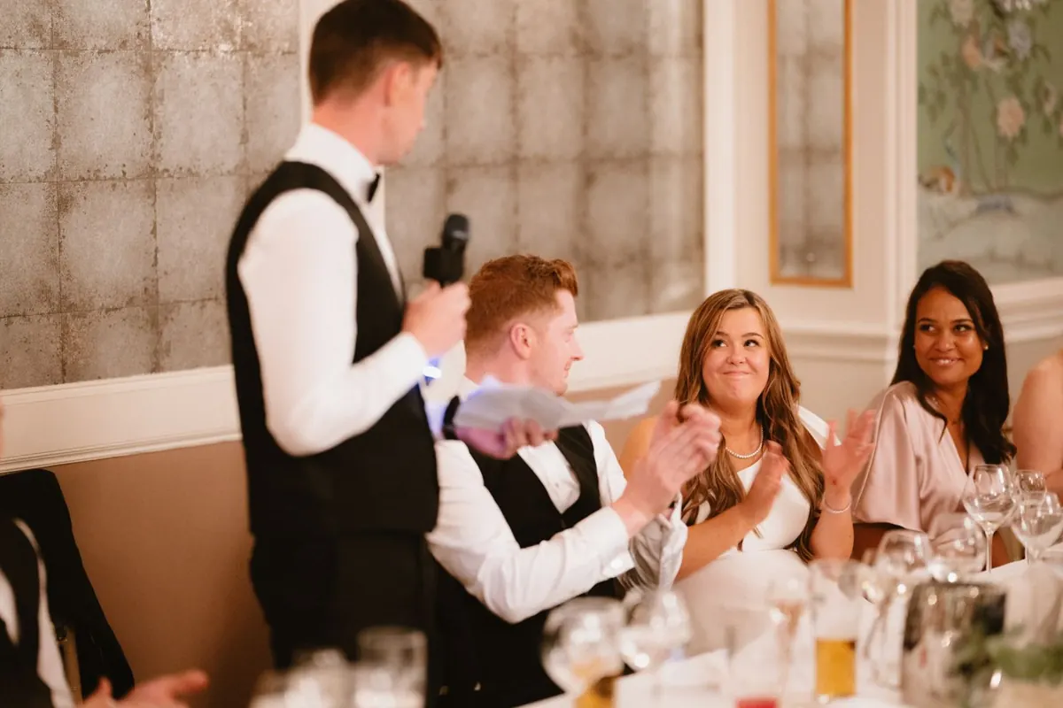 A guest giving a speech while the seated couple react