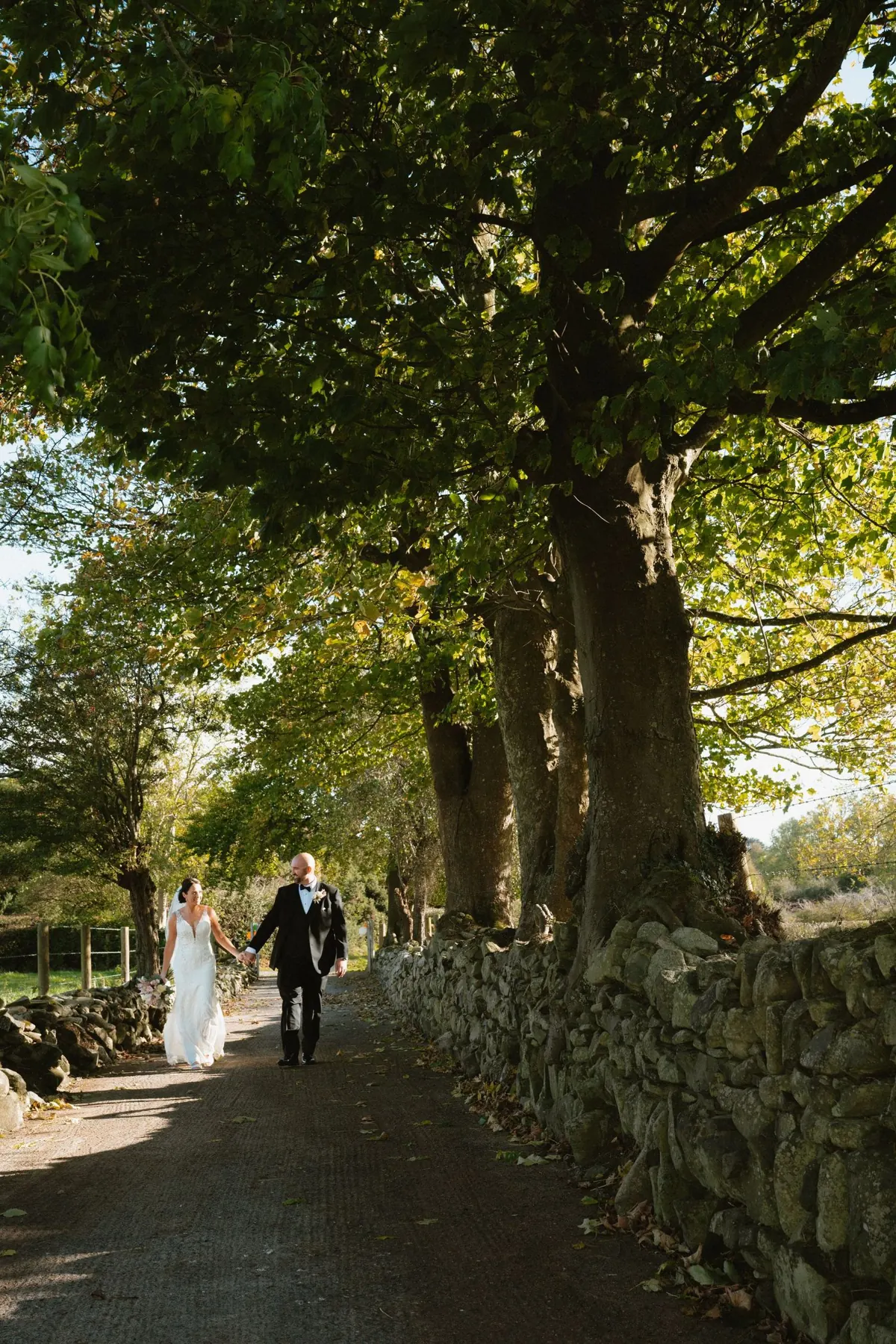 Tree-lined walk with bride and groom outside Killeavy Castle in Northern Ireland