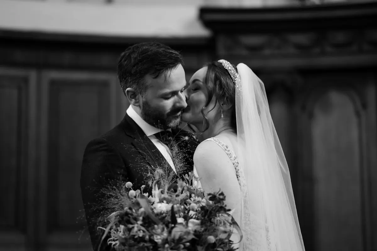 A quiet black-and-white portrait of Carole and Stephen in the chapel