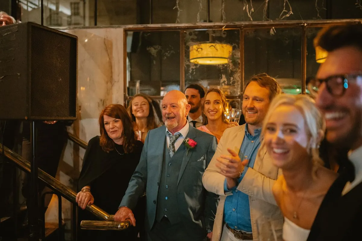 Guests laughing together beside the reception bar