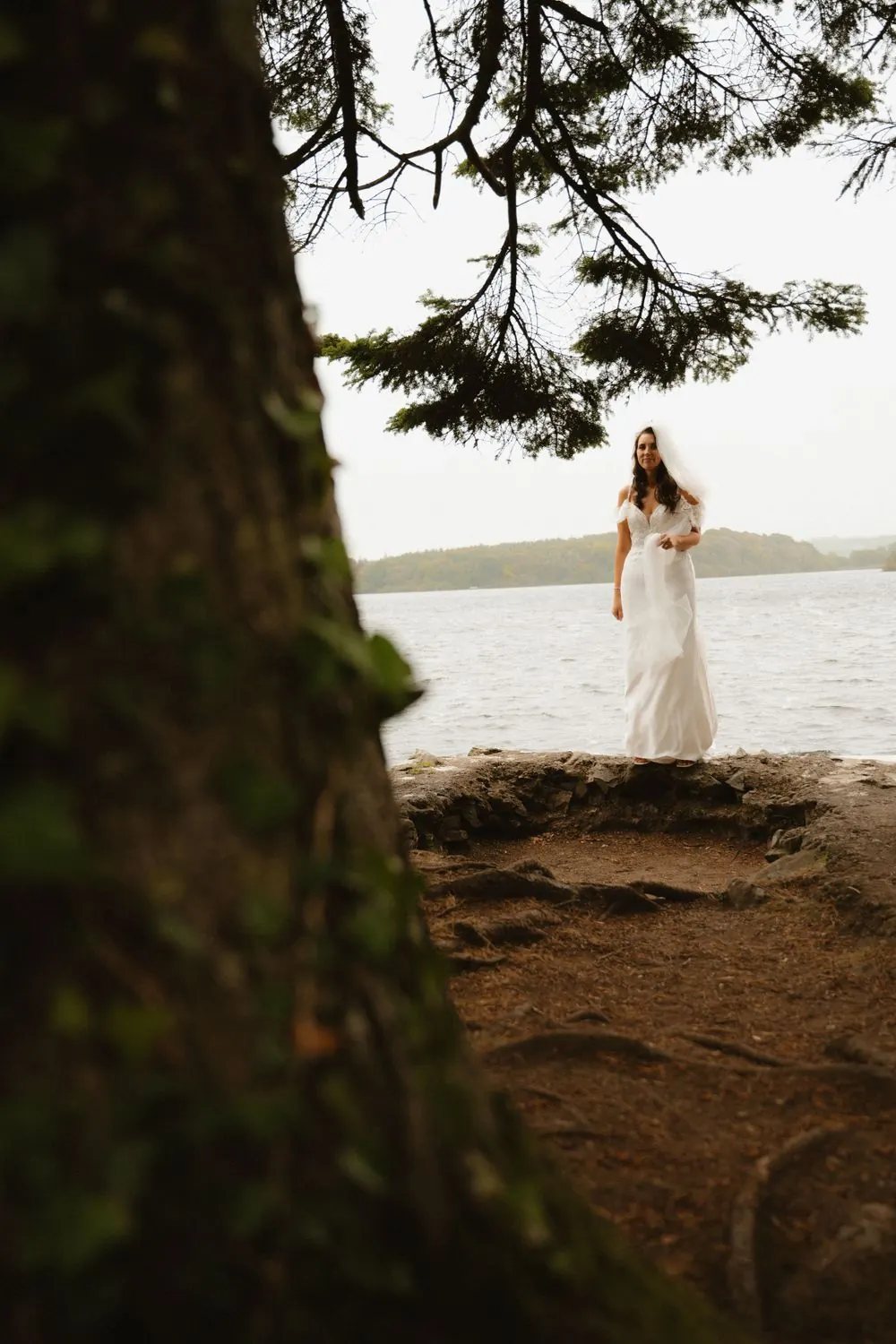 Aine framed by a tree on the lakeside.