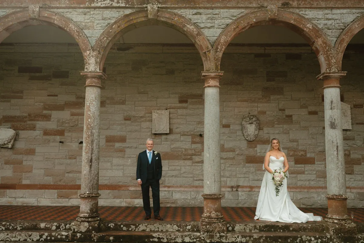 Wedding couple framed by stone arches at Castle Leslie Estate.