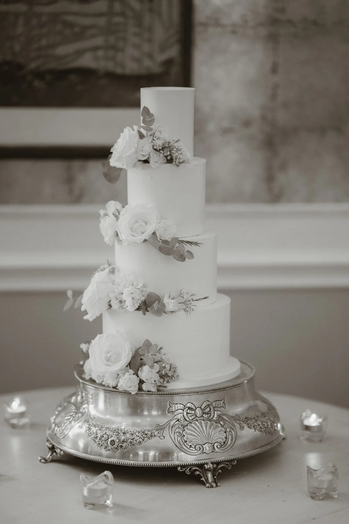 Black and white photograph of a white cake with floral decoration