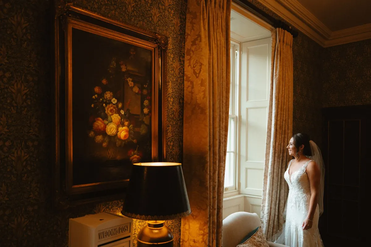 Bride beside a window in the richly decorated interior of Killeavy Castle.