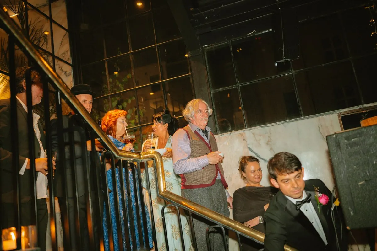 Guests gathered beside the stairs and windows during the reception