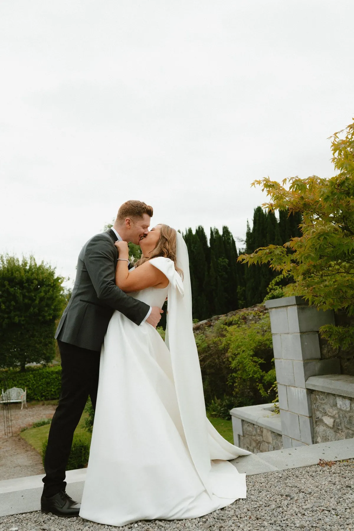 The couple embracing beside the garden fountain