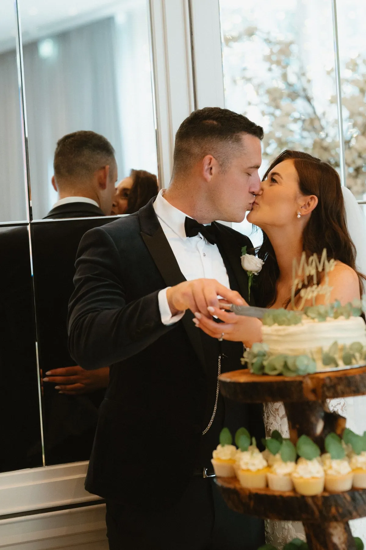 The couple kissing beside the cupcake display
