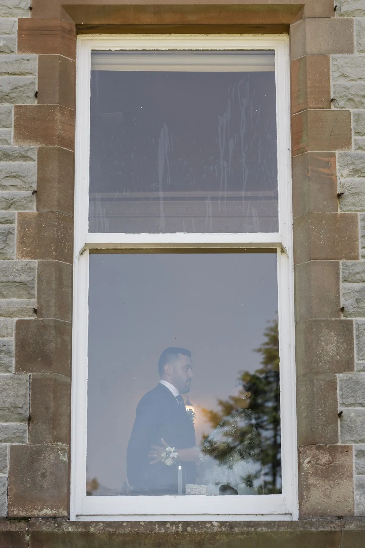 Ramon seen through a window before the outdoor ceremony