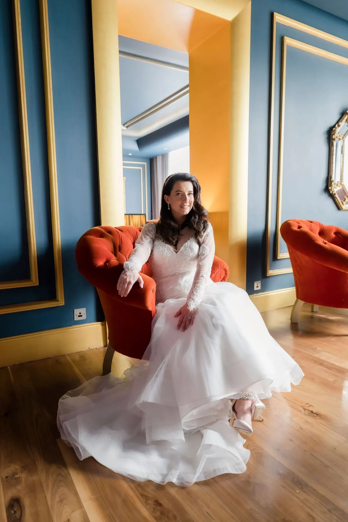 Michelle in a colourful hotel room beside a bright window.