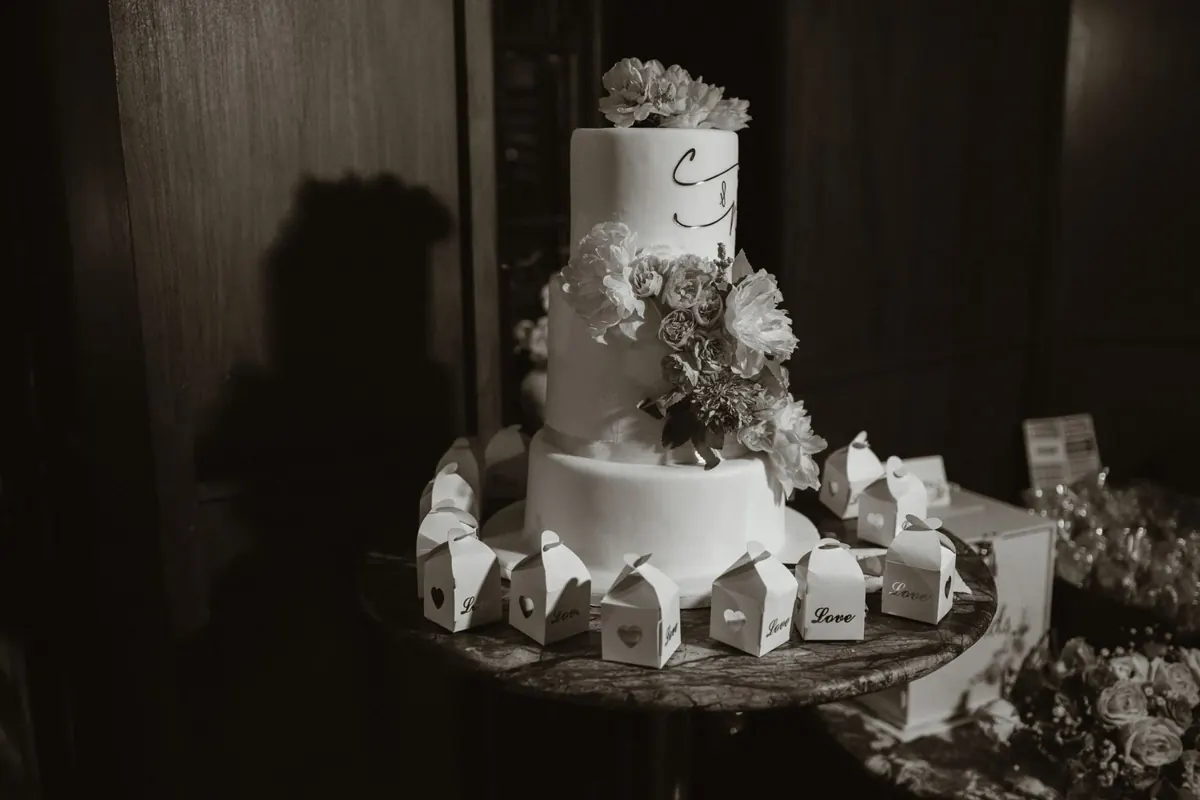 Black and white photograph of the wedding cake and cards on a table