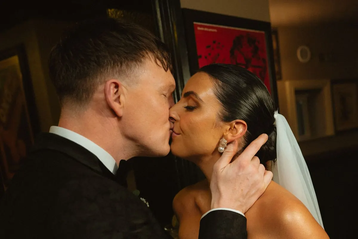 Close photograph of the couple kissing indoors