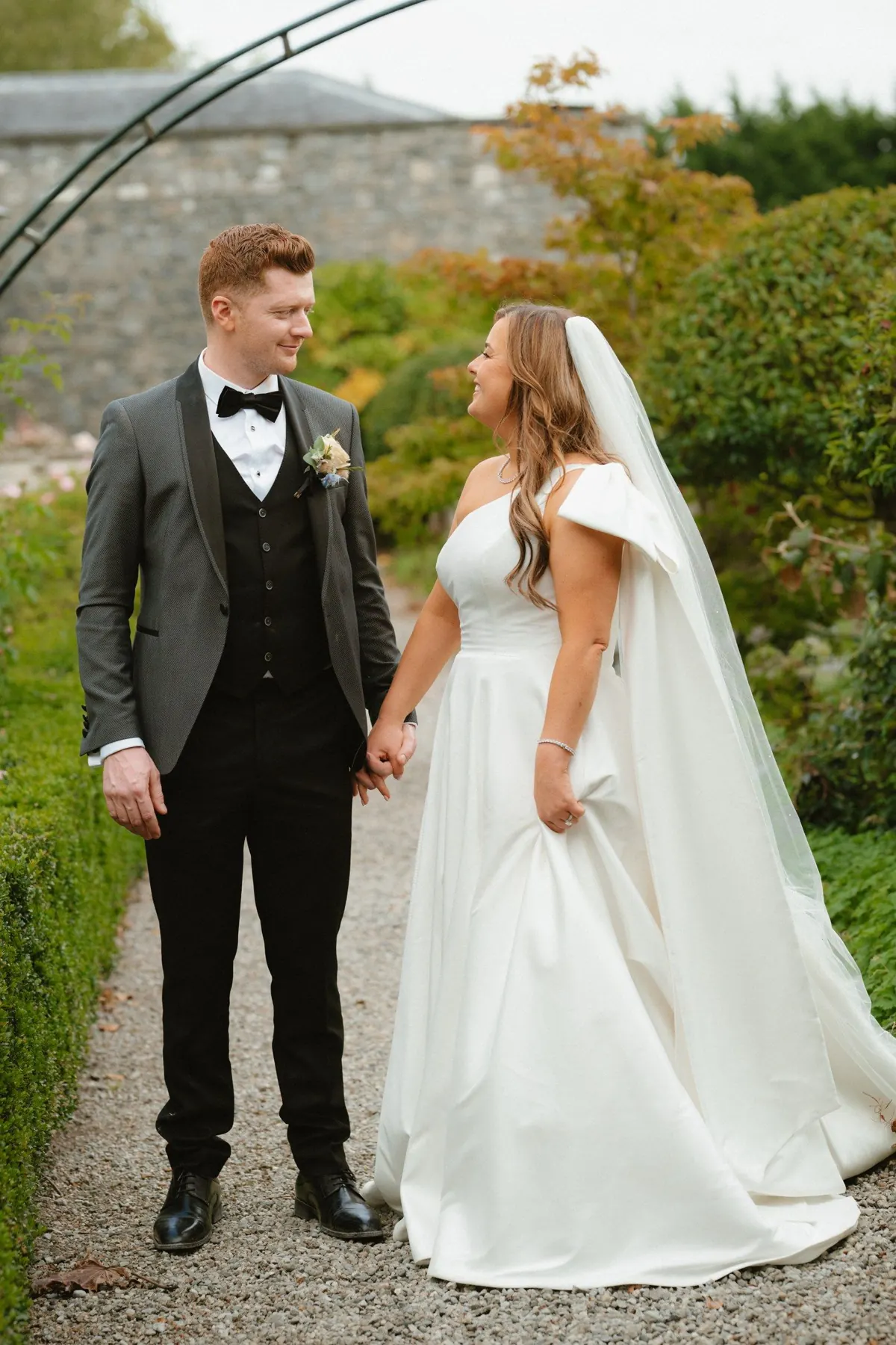 The couple looking at each other on a garden path