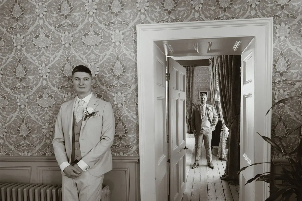 Black and white portrait with the grooms framed by an interior doorway