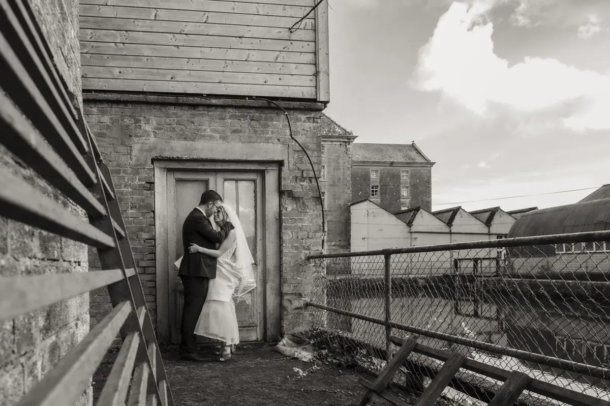 The couple together in a doorway beside the mill buildings