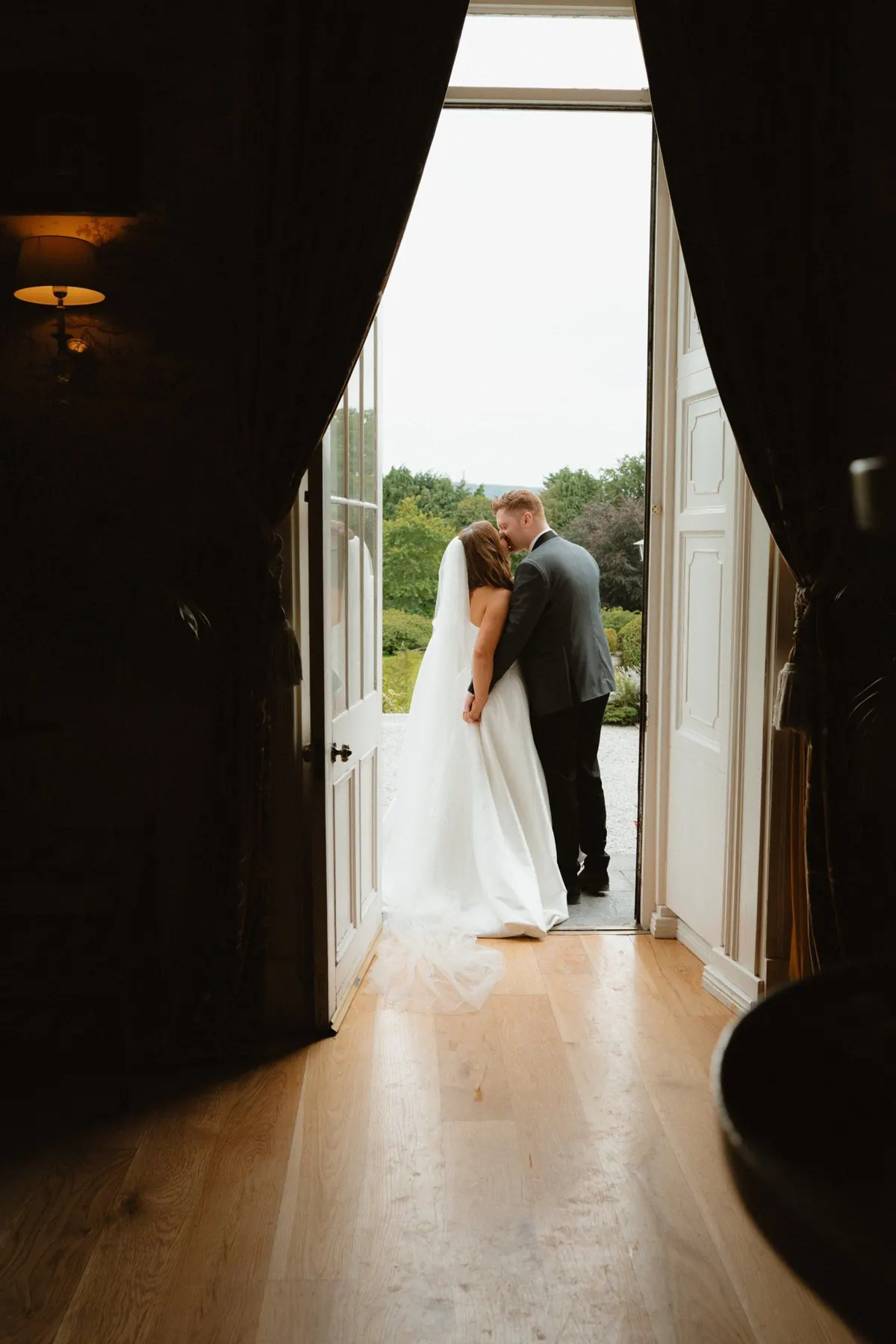 The couple kissing in an open doorway leading outside