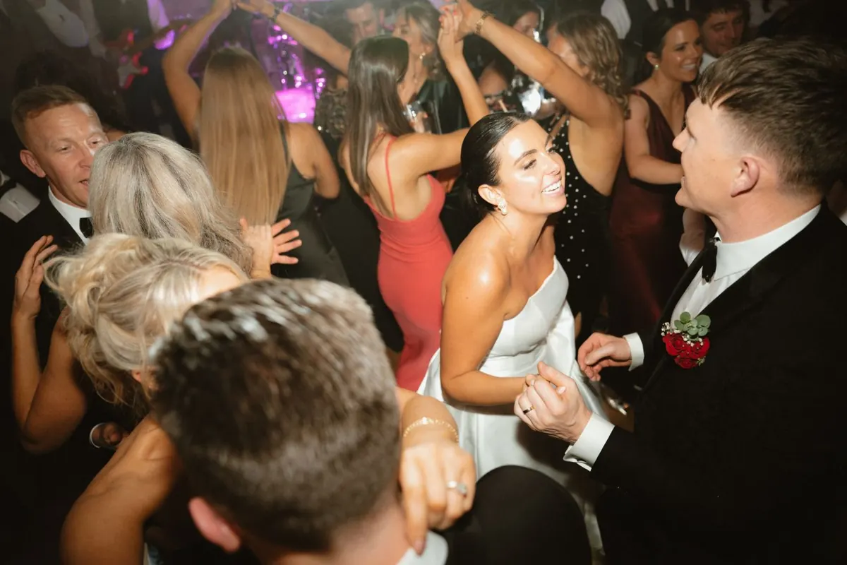 Guests gathered closely around the smiling couple on the dance floor