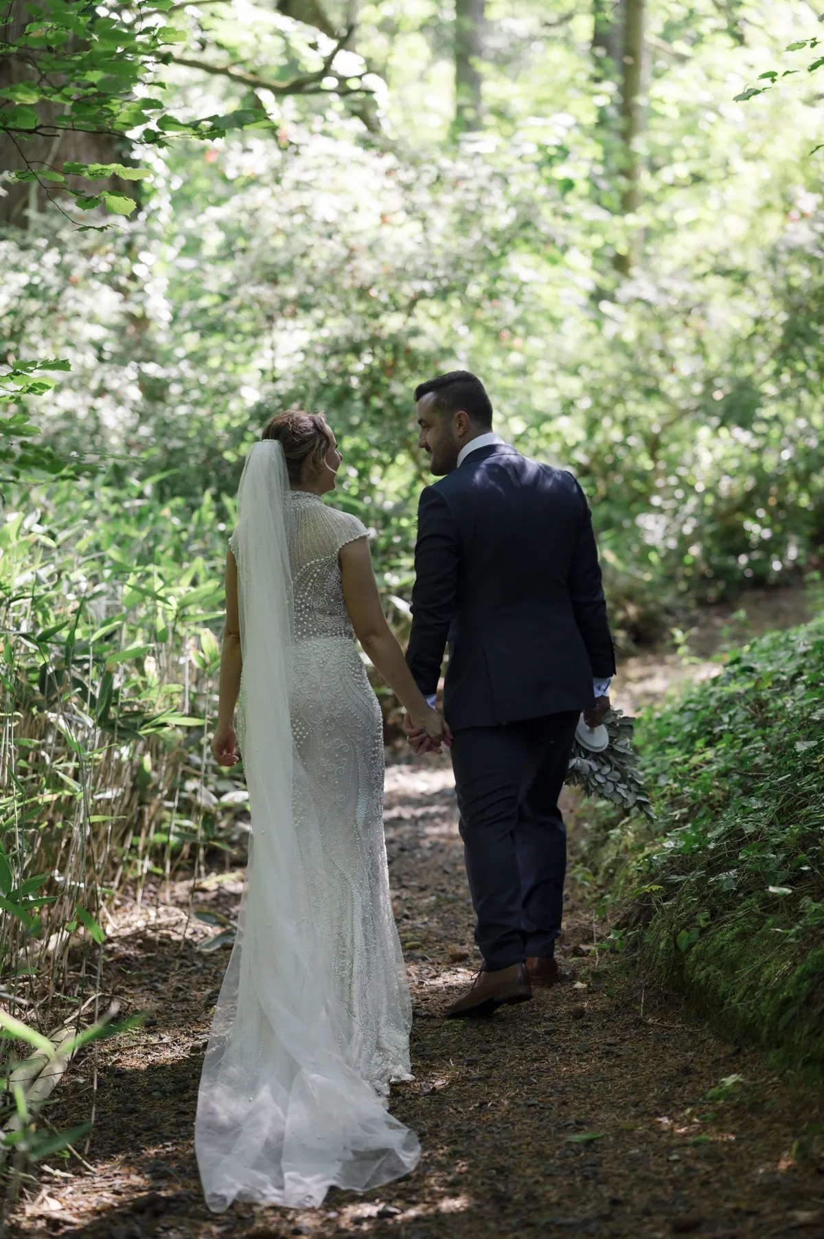 The couple walking along a shaded woodland path
