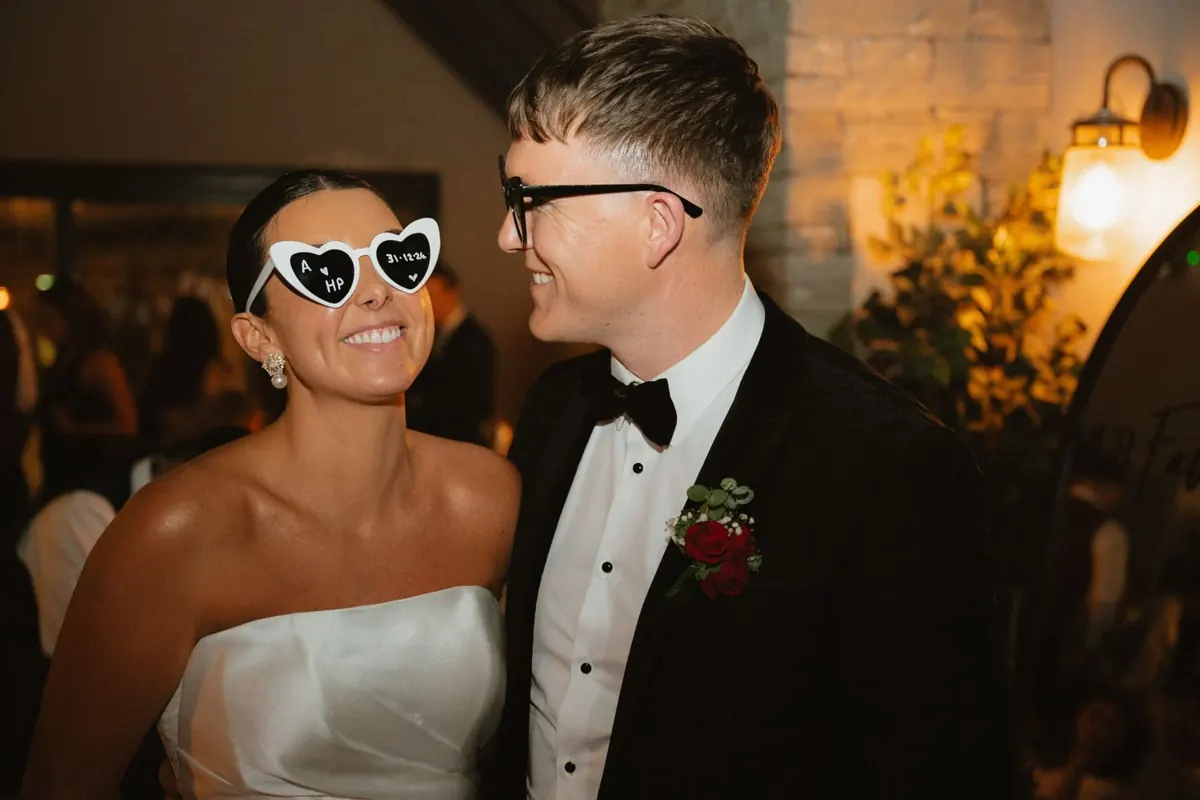 The bride wearing heart-shaped sunglasses beside the groom
