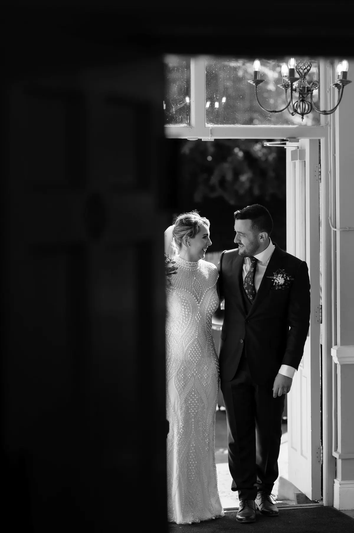 Steph and Ramon framed in a shadowed estate doorway