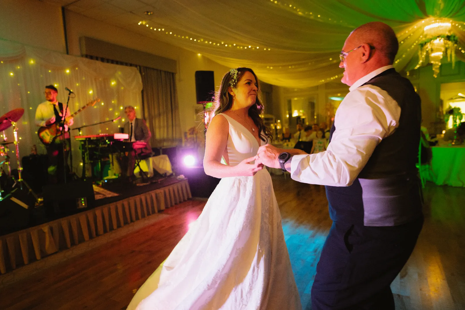 The couple dancing under coloured lights