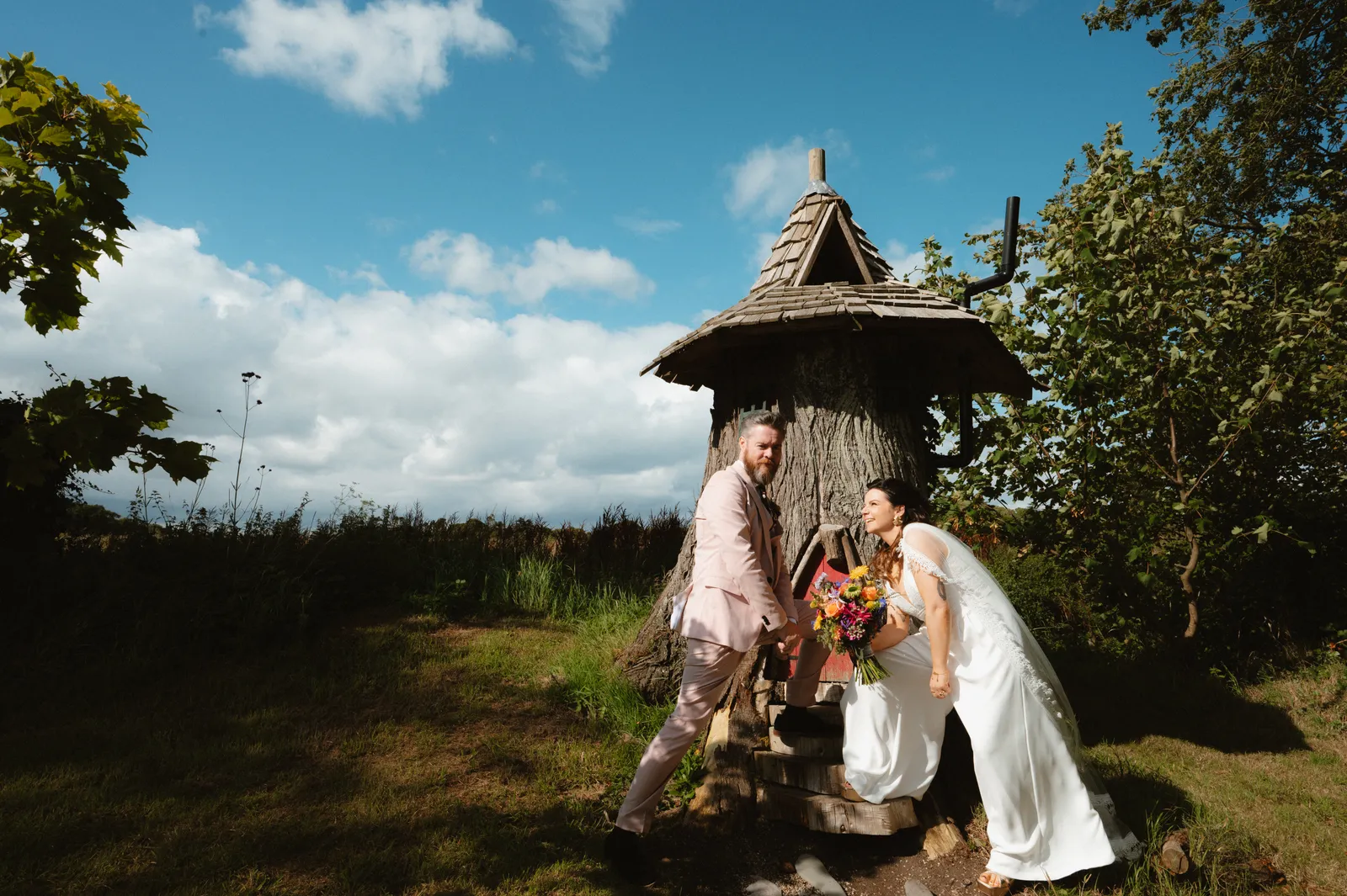 Aoife and Ben beside a thatched garden shelter at Segrave Barns