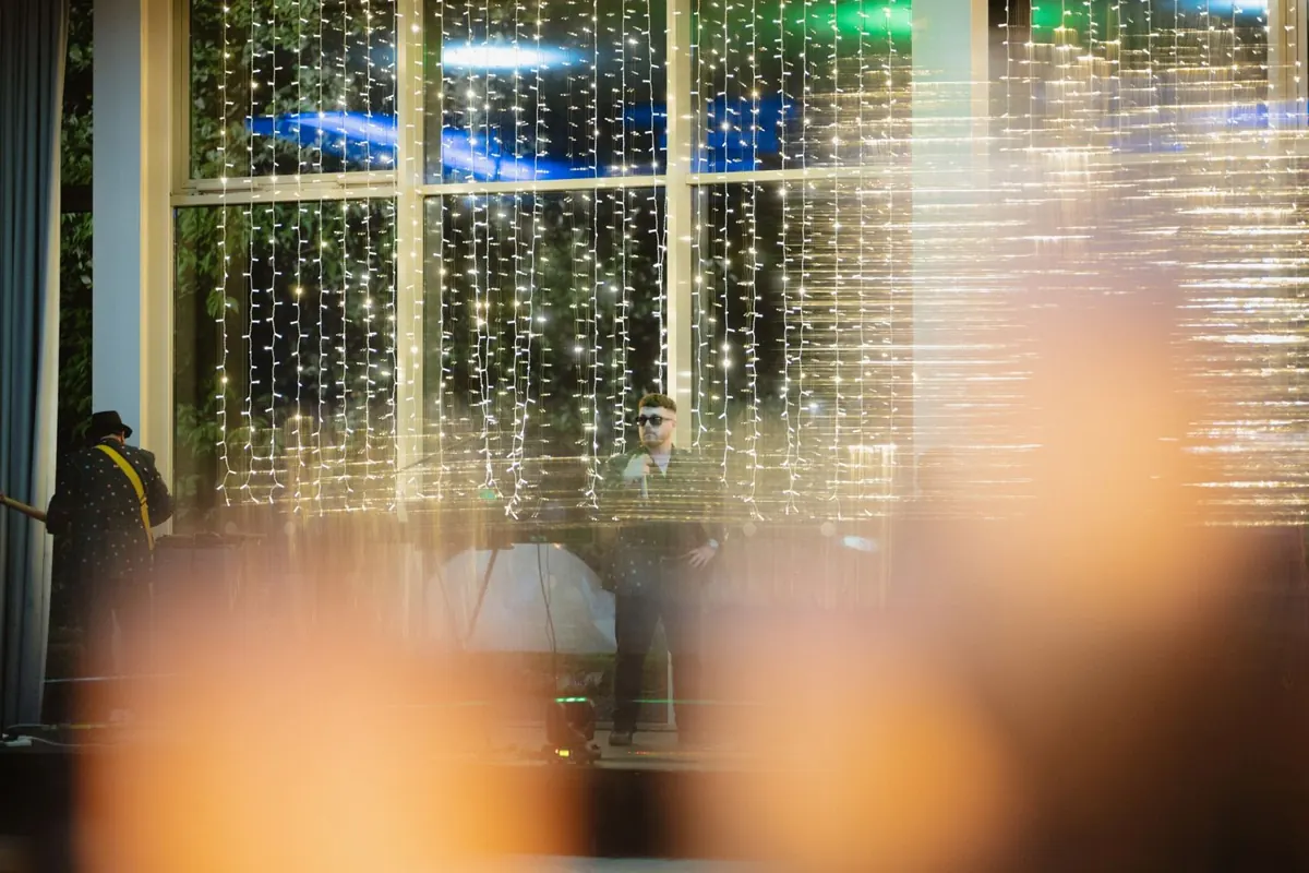 Strings of warm lights reflected in the reception windows