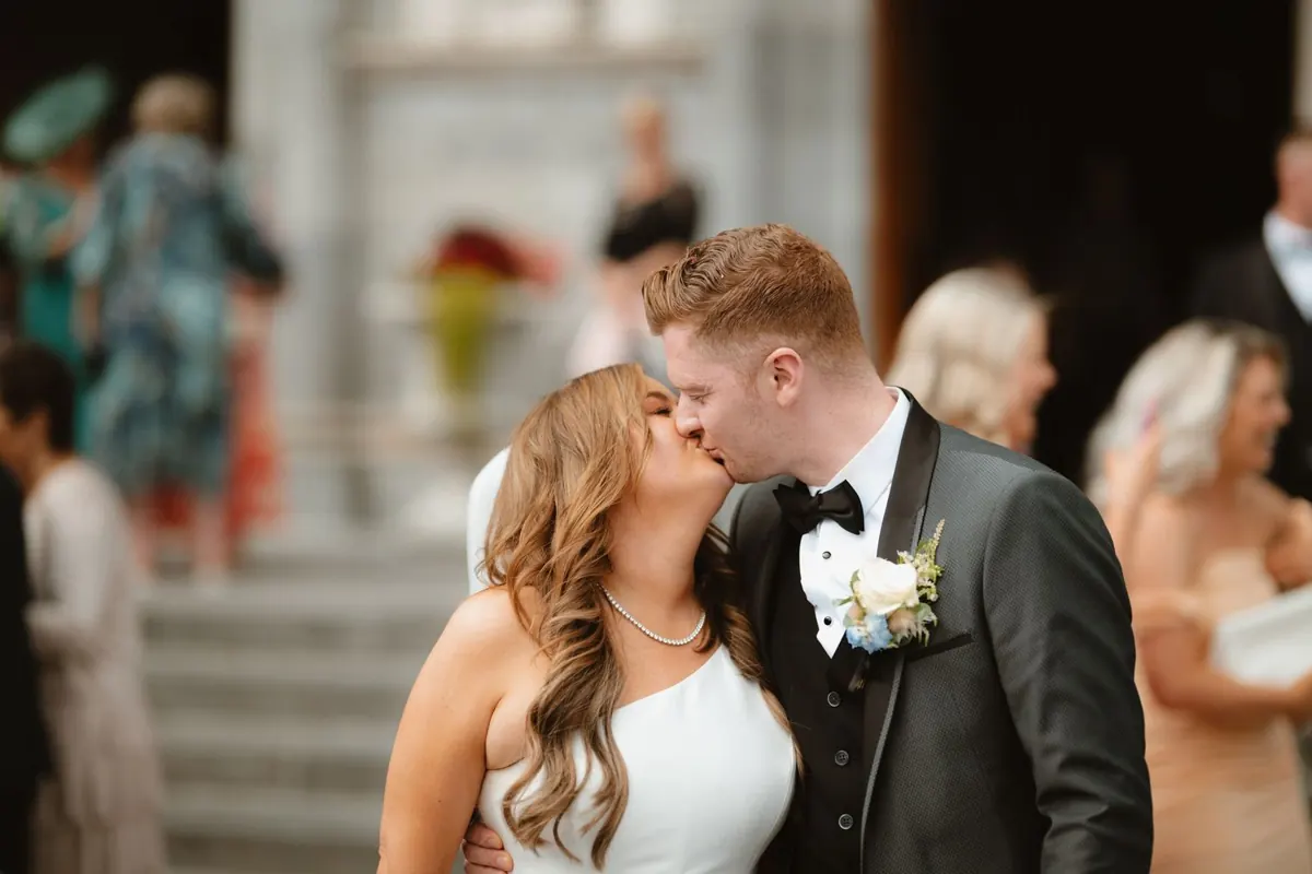 The groom kissing the bride’s forehead during the reception