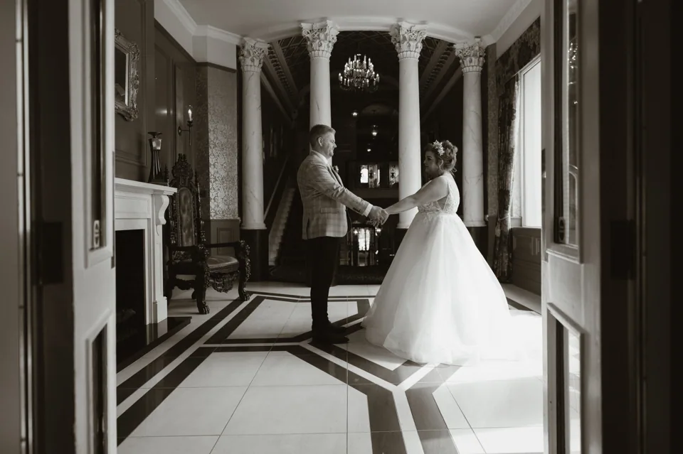 The couple standing in the dark-panelled room