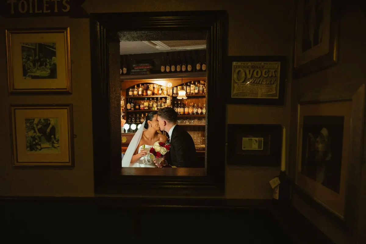 The couple at the bar reflected in a wall mirror