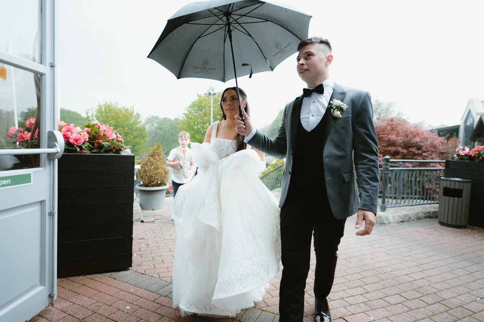 Brogan and Thomas walking beneath an umbrella