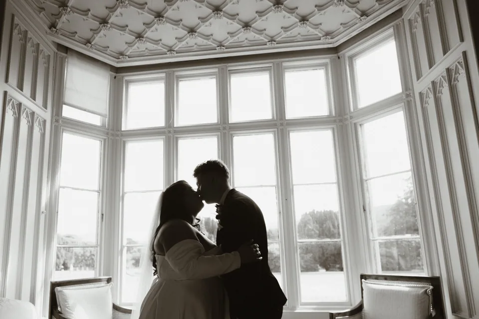 The couple silhouetted at a large window