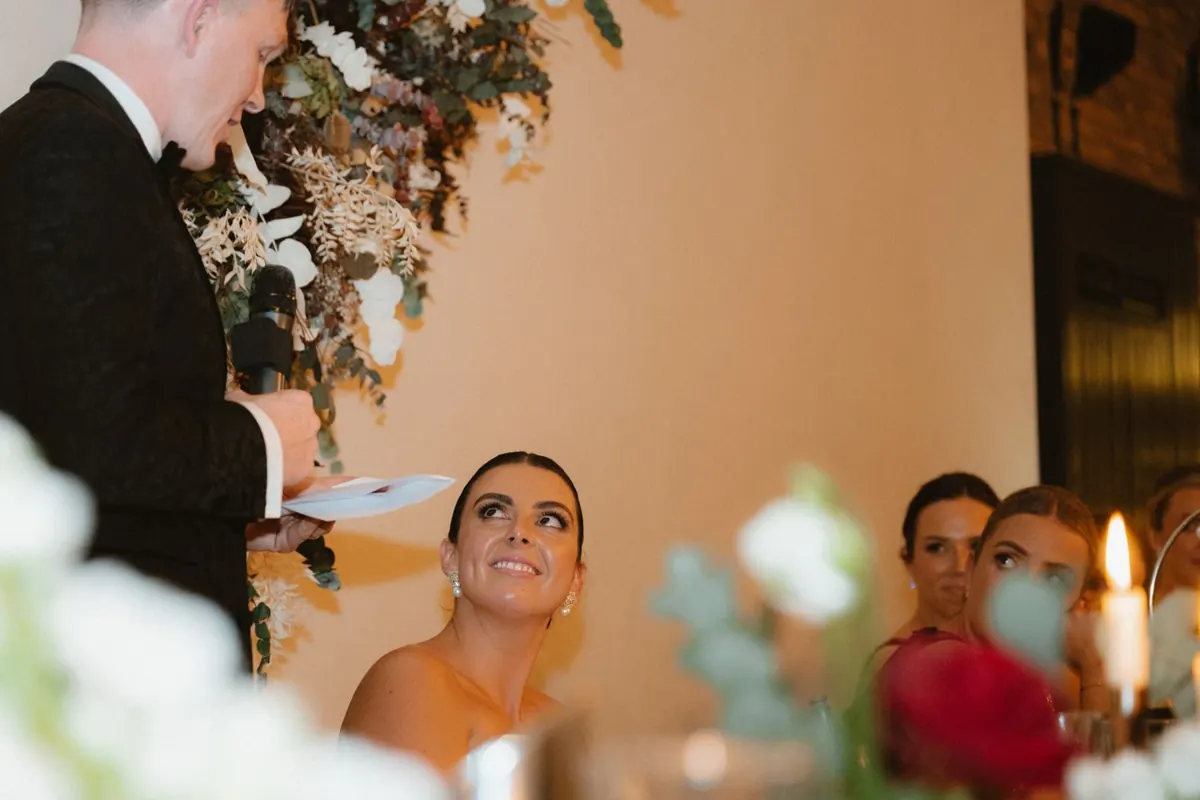 The bride looking up at the groom during his speech