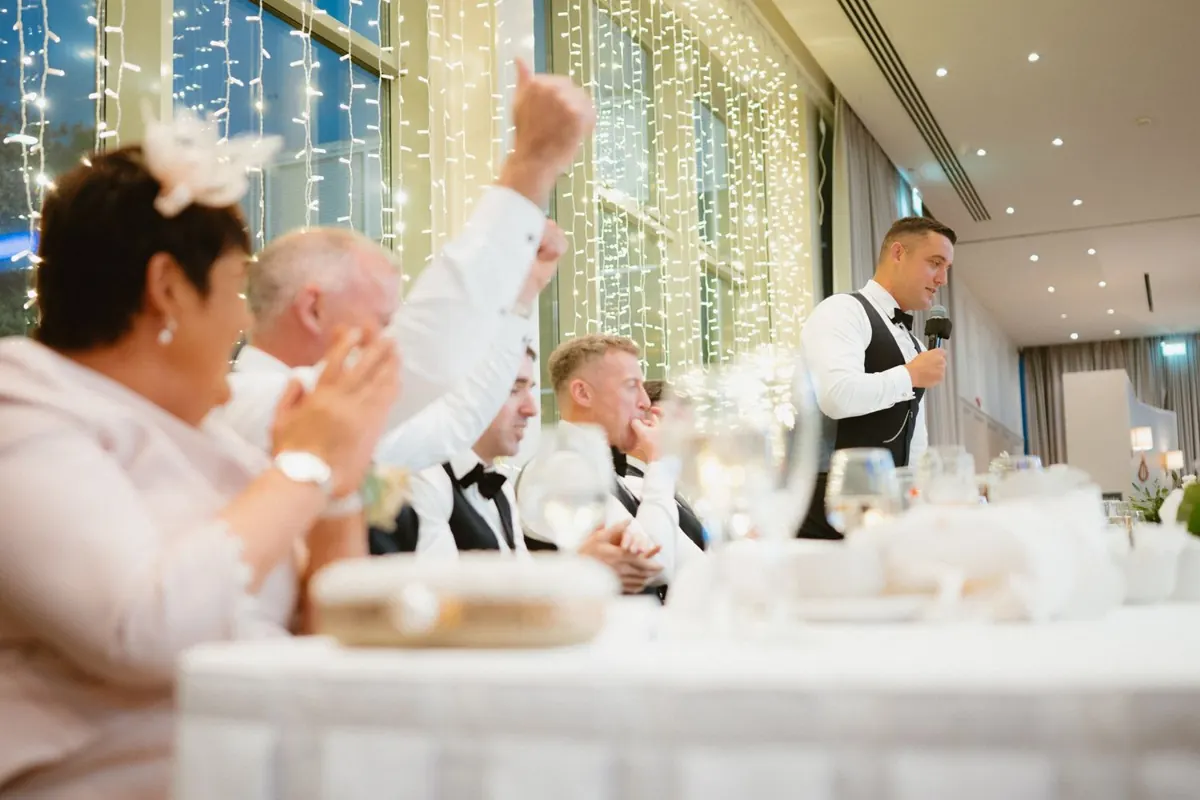 Guests cheering and raising their arms around the reception tables