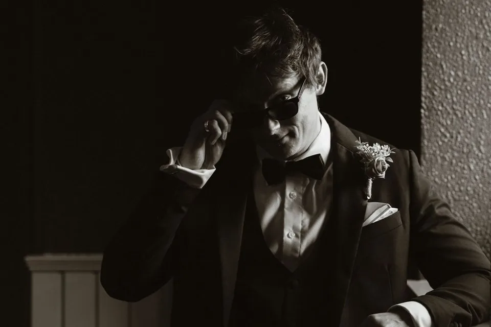 Groom in black tuxedo and bow tie at Boyne Hill House, in a dramatic black and white wedding portrait.