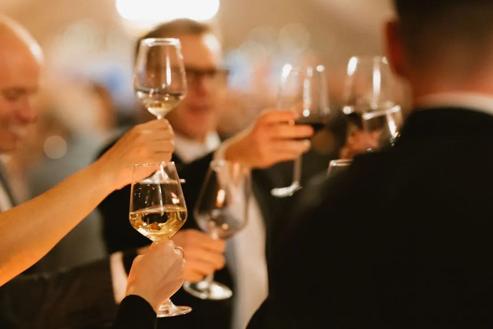 Guests raising wine glasses in a celebratory toast at an elegant Boyne Hill House Estate wedding reception in Co.Meath
