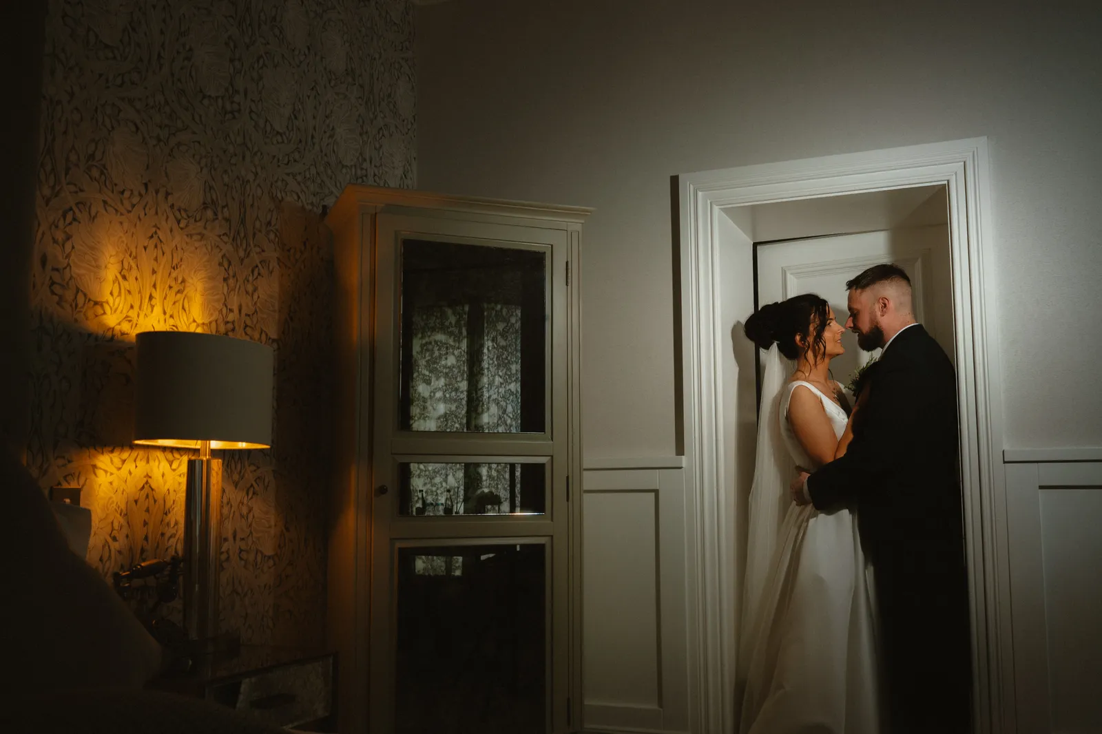 The couple together in a warmly lit doorway