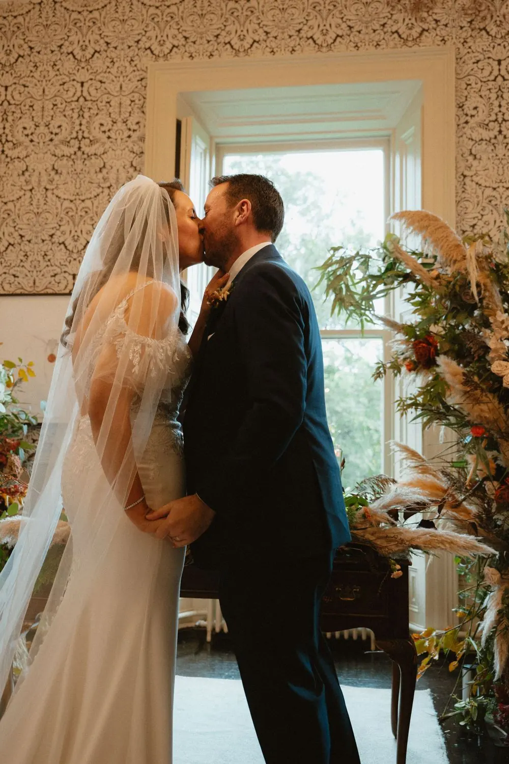 Aine and John kissing during their wedding ceremony.
