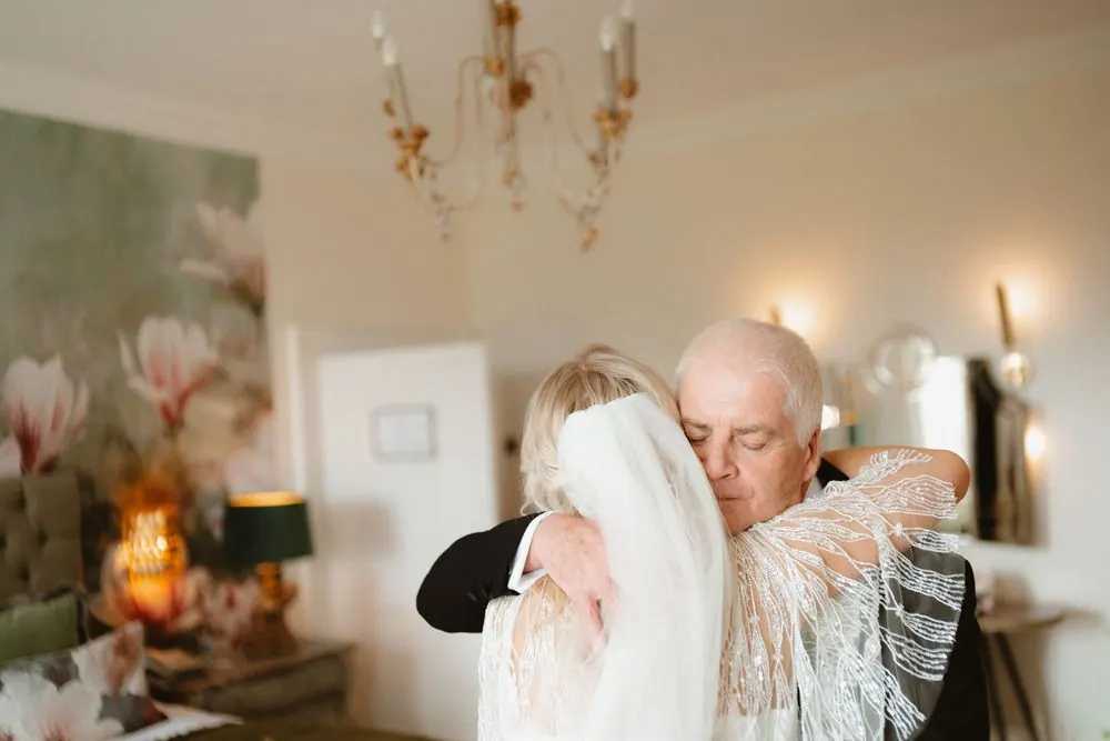 A bride and father share a tender embrace in an elegant room at Boyne Hill House Estate, Co. Meath