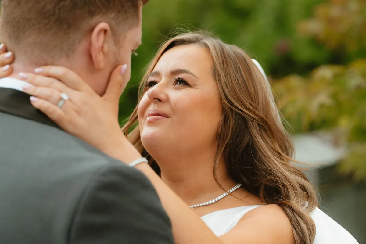 Close portrait of the bride touching the groom’s neck