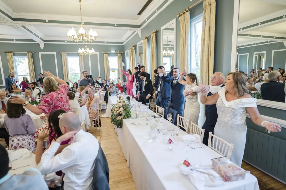 The reception room with guests and flowers along the tables