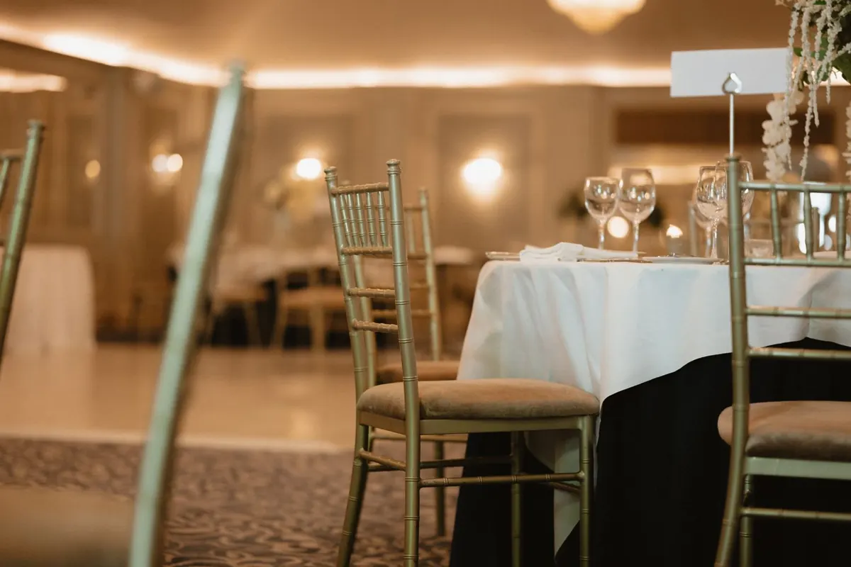 Reception tables set with gold chairs and candles