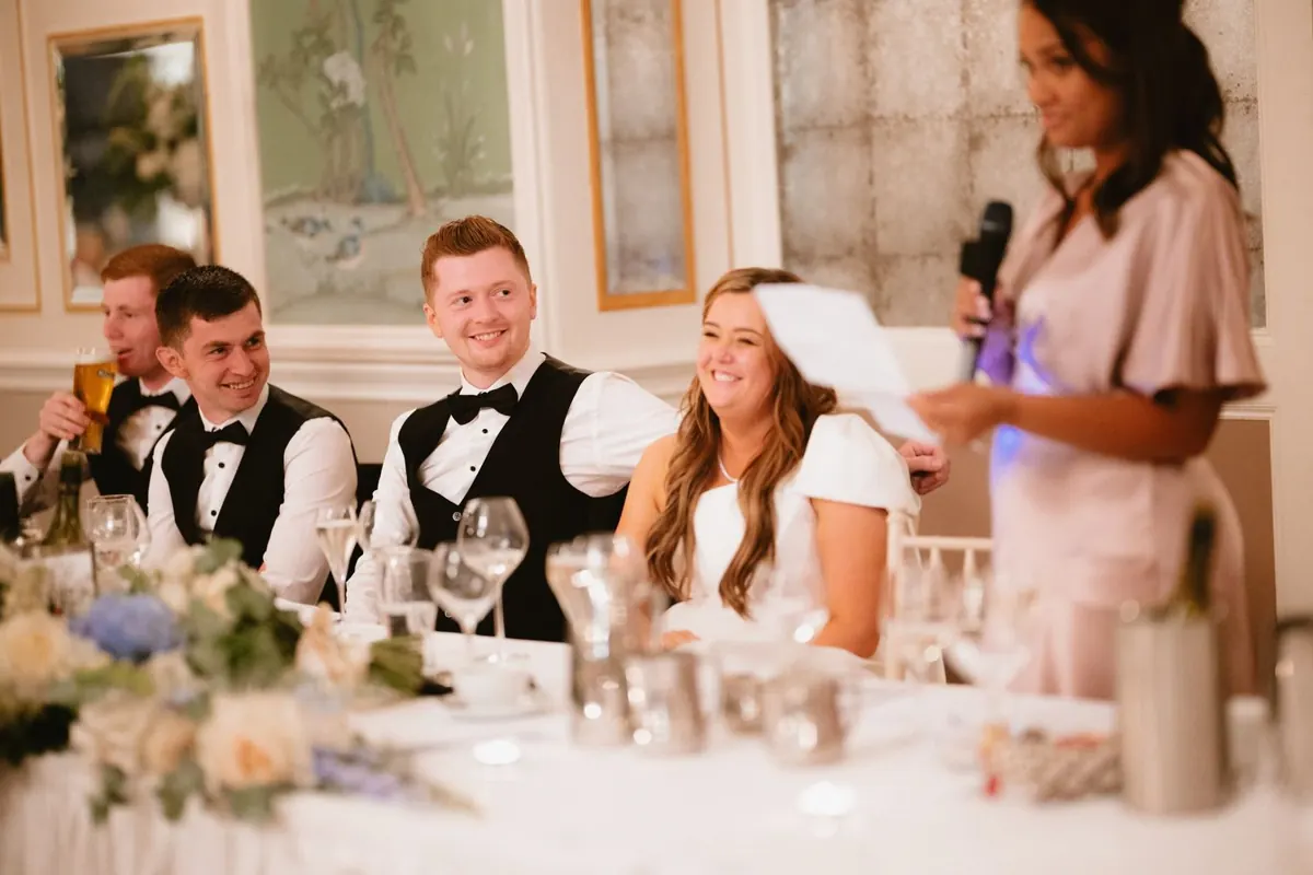 A guest speaking beside the couple at the top table
