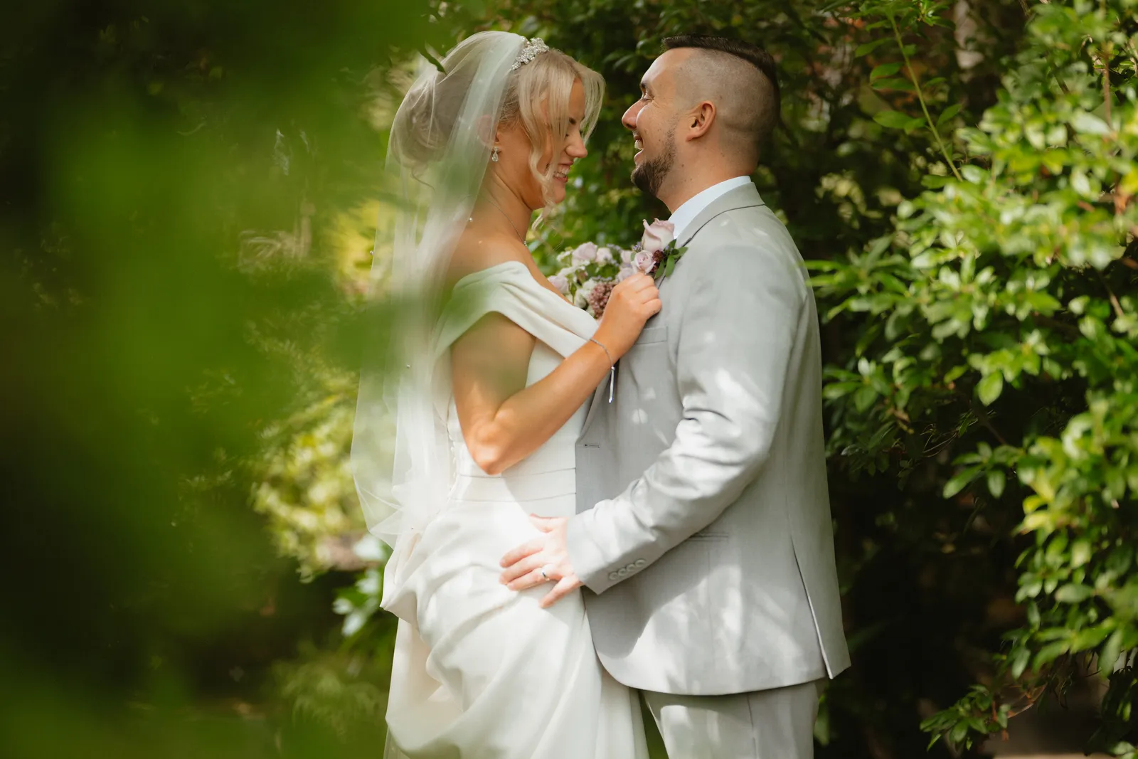 The couple lean close among the leaves