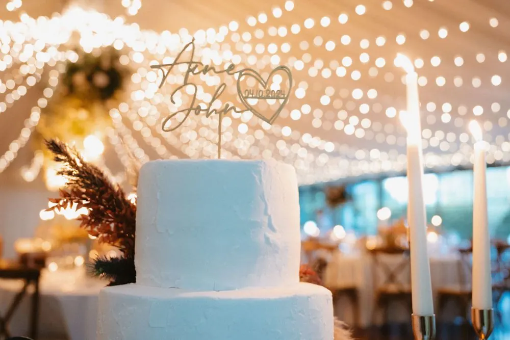 The wedding cake beneath warm reception lights.
